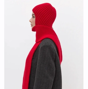 Detail of red knitted balaclava hood worn with a gray wool coat for winter warmth