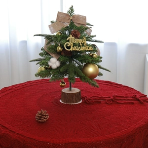 Red chunky knit Christmas tree skirt with cable pattern and festive ribbon ties