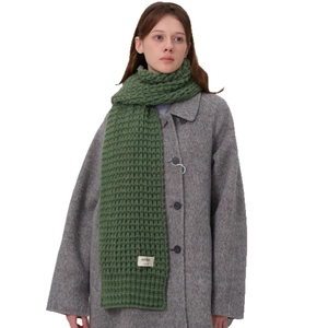 Sciarpa spessa in maglia verde con etichetta abbinata a un cappotto grigio di lana