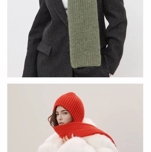 Detail view of knitted hooded scarves in green and orange with thick ribbed texture