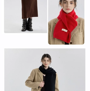 Dettaglio di sciarpe in maglia rossa e nera abbinate a blazer autunnale e stivali