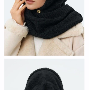 Detailed close-up of a black knit balaclava scarf with decorative gold metal buckle