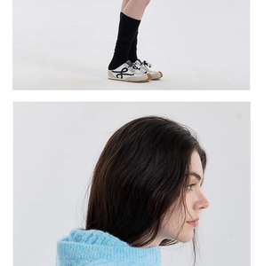Detail of wool blend cable knit balaclava hat and designer sneakers styling
