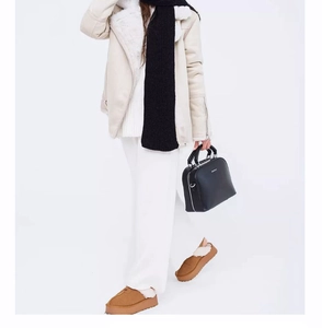 Close-up of winter outfit featuring platform snow slippers with cozy faux fur lining