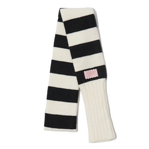 Écharpe en maille rayée noire et blanche avec étiquette rose sur un fond blanc neutre