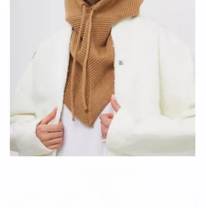 Detail of beige knitted balaclava hood with drawstring paired with fuzzy fleece collar