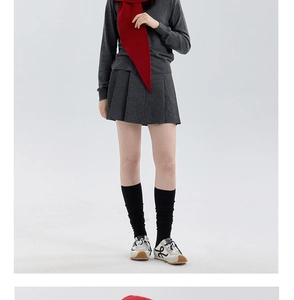 Detail of red knit scarf paired with a grey knitted top and pleated mini skirt outfit