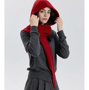 Detail view of red knitted hooded scarf with vertical ribbed texture for winter warmth
