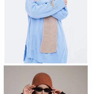 Detail view of sky blue knit sweater with beige ribbed scarf and tan winter beanie hat