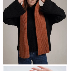 Detail of rust red ribbed knit hooded scarf showing thick texture and warm winter material