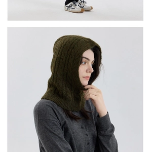 Detail of dark green cable knit balaclava showing thick wool blend texture and ribbed edges