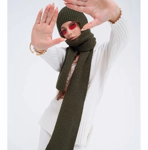 Detailed texture of dark moss green ribbed knit hooded scarf and beanie set for winter