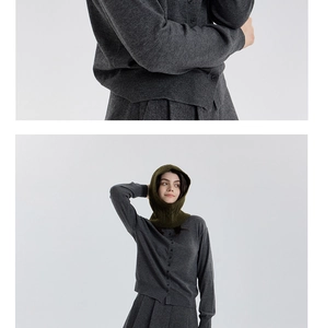 Detail of grey cable knit wool blend cardigan and olive green balaclava hood texture