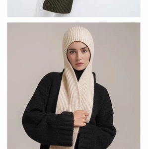 Close-up of cream chunky ribbed knit balaclava scarf paired with a black plush coat