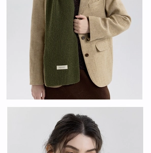 Detailed knit texture and designer label of this dark green cashmere-style scarf