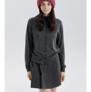 Texture détaillée du cardigan en tricot gris foncé épais et du tissu de la jupe plissée