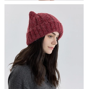 Gros plan détaillé sur la texture douce en mohair et le design oreilles de chat du bonnet rouge