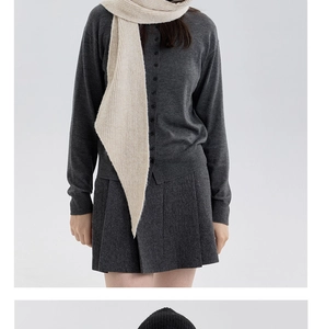 Close-up of fine texture on grey knitted cardigan and beige scarf set for winter