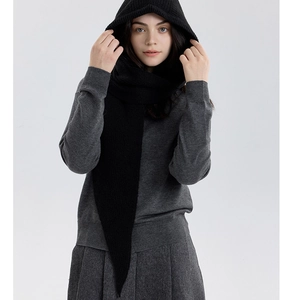 Detail of black knitted hooded scarf shawl with soft texture on a fashion model
