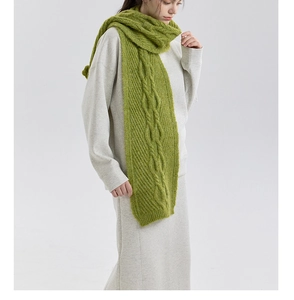 Detailed close-up of grass green cable knit scarf showing thick wool blend texture