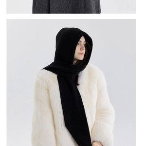Detail of black thick chunky knit hooded scarf on a model with white faux fur coat