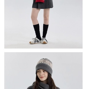 Detail view of dark grey Fair Isle knit beanie and pleated woolen skirt ensemble