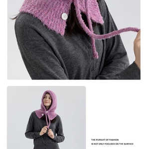 Detail of purple knitted balaclava with white buttons and thick wool blend texture
