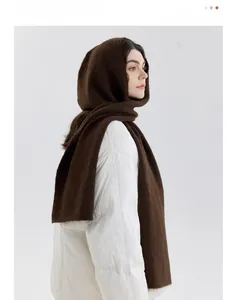 Detail view of brown knitted hooded scarf showing soft plush texture and warm material