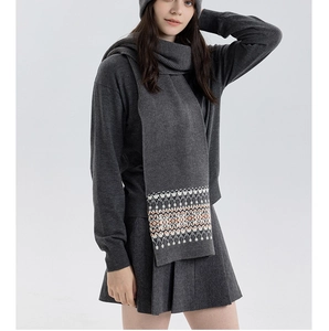 Detail of the Fair Isle geometric knit pattern on a dark grey winter scarf and hat set