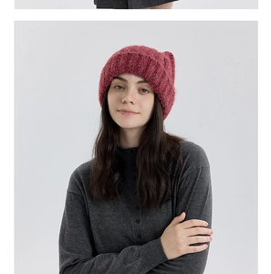 Détail du bonnet rouge à oreilles de chat montrant la maille épaisse et la texture douce
