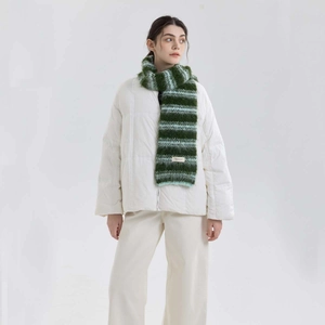 Sciarpa in maglia a righe misto lana verde e bianca indossata con un piumino beige