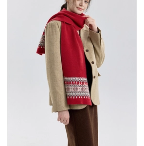 Detail of red Nordic Fair Isle knitted scarf with vintage geometric patterns and soft texture