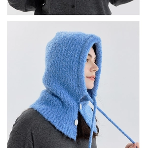 Detail of bright blue wool-blend balaclava featuring white button closure and drawstrings