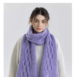 Detailed macro view of purple chunky knit scarf featuring classic cable pattern texture
