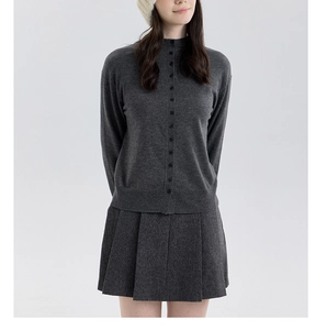 Détail d'un ensemble deux pièces tricoté gris foncé avec cardigan et jupe plissée