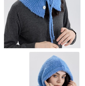 Detail of blue boucle wool balaclava featuring knit texture and a single white button