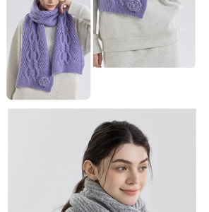 Detail of cable knit scarf featuring handmade floral accents and thick warm texture