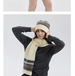 Close-up of Fair Isle knit beanie and scarf set with geometric patterns in cream and brown