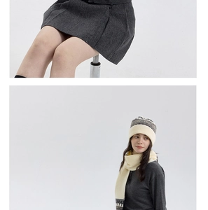 Detail of white Fair Isle knit winter set including hat and scarf with tassels