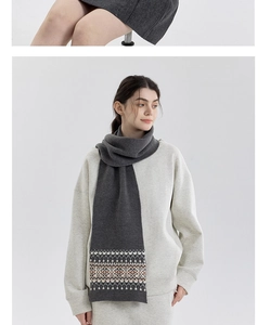 Detail of gray Fair Isle knit scarf featuring geometric patterns and soft wool texture