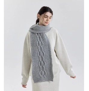 Detailed close-up of thick grey cable knit scarf showing soft chunky wool texture