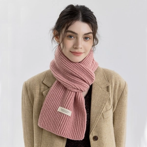 Pink chunky knit scarf with minimalist logo label on soft cashmere-like fabric