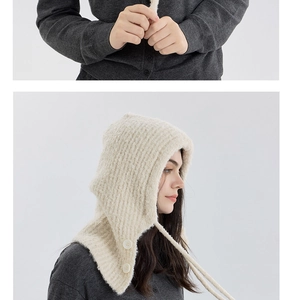 Macro detail of beige boucle knit balaclava showing soft texture and button closure