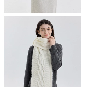 Close-up of thick cable knit pattern on a soft white winter scarf for women