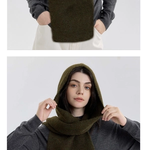 Detail of dark green knitted hooded scarf showing soft wool texture and wrap-around fit