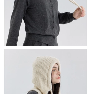 Detail of a creamy white boucle balaclava paired with a dark grey knit cardigan