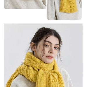 Dettaglio di sciarpa in maglia giallo zenzero con motivo a trecce e trama a coste spesse