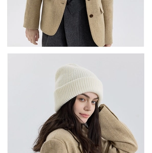 Detail of off-white ribbed wool knit beanie paired with a camel tweed blazer jacket