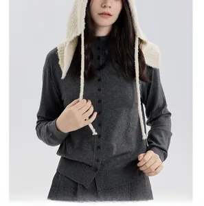 Close-up of white chunky knit balaclava hood with long ties and dark grey cardigan