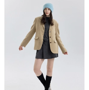 Detail of wool knit beanie paired with a wool blazer and pleated skirt in a classic outfit